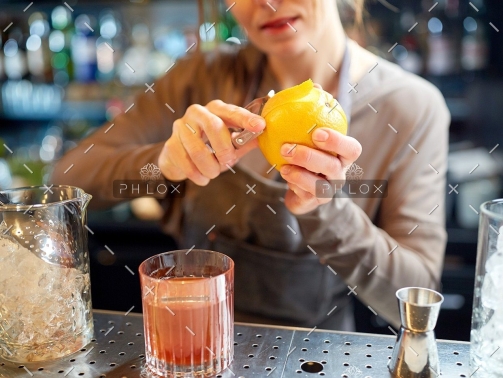 demo-attachment-18-bartender-peels-orange-peel-for-cocktail-at-bar-P97775Y